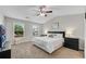 Comfortable main bedroom featuring a ceiling fan, plush carpet, and bright windows with green outdoor views at 562 Poplar Bnd, Canton, GA 30114
