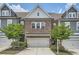Charming townhome featuring a brick facade, two-car garage, and beautifully landscaped front yard at 2543 Oakbourne Ln # 14, Smyrna, GA 30080