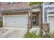 Attached garage and entryway of brick townhome with neatly trimmed landscaping and modern design at 2543 Oakbourne Ln # 14, Smyrna, GA 30080