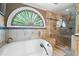 Luxurious bathroom features a soaking tub and a glass enclosed shower with travertine tile at 465 Willowbrook Se Dr, Smyrna, GA 30082