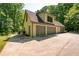 Exterior of a light-colored home with a three-car garage surrounded by lush greenery at 465 Willowbrook Se Dr, Smyrna, GA 30082
