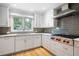 Modern kitchen featuring white cabinets, stainless steel appliances, and granite countertops at 465 Willowbrook Se Dr, Smyrna, GA 30082