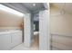 Clean laundry room with washer, dryer, shelving, and a connecting door leading to another room at 465 Willowbrook Se Dr, Smyrna, GA 30082