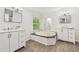 Bathroom featuring dual vanities, a soaking tub, natural light, and modern fixtures at 6670 George Ct, Cumming, GA 30041