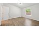 Bright bedroom with wood floors, white walls, and natural light from the window at 6670 George Ct, Cumming, GA 30041