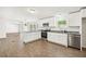 Modern kitchen featuring white cabinets, stainless steel appliances, and an island with granite countertops at 6670 George Ct, Cumming, GA 30041