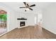 Spacious living room featuring a fireplace, ceiling fan, and door leading to other areas of the home at 6670 George Ct, Cumming, GA 30041