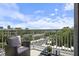 Relaxing balcony with a wicker chair, glass table, and views of the city and trees at 1820 Peachtree St # 614, Atlanta, GA 30309