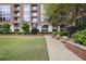 Exterior of brick building with green lawn, brick walkway, benches, and manicured shrubs at 1820 Peachtree St # 614, Atlanta, GA 30309