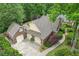 Aerial view highlights the home's attached garage and the manicured lawn surrounded by mature trees at 3456 Drayton Ne Dr, Roswell, GA 30075