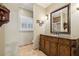Bathroom vanity featuring granite countertop, wood cabinets, and decorative mirror at 3456 Drayton Ne Dr, Roswell, GA 30075