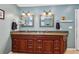 Bathroom featuring a dual sink vanity with granite countertop and framed mirrors at 3456 Drayton Ne Dr, Roswell, GA 30075