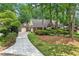 Exterior of the home features a well-maintained lawn, mature trees, brick facade, and a three-car garage at 3456 Drayton Ne Dr, Roswell, GA 30075