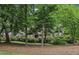 View of a home partially obscured by mature trees, providing a sense of privacy and seclusion at 3456 Drayton Ne Dr, Roswell, GA 30075