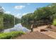Scenic view of the lake with a wooden dock, lush greenery, and reflections of the sky at 3456 Drayton Ne Dr, Roswell, GA 30075