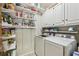 Laundry room with washer, dryer, white shelving, and ample storage at 3456 Drayton Ne Dr, Roswell, GA 30075