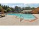 Beautiful in-ground pool with a slide, lounge chairs, tables, and a lifeguard stand in the background at 3456 Drayton Ne Dr, Roswell, GA 30075