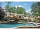 Backyard view of a swimming pool with a yellow house, mature trees, and lovely landscaping at 3456 Drayton Ne Dr, Roswell, GA 30075