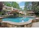 Backyard view showcasing a sparkling swimming pool with stone edging and a yellow house in the background at 3456 Drayton Ne Dr, Roswell, GA 30075
