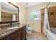 Bathroom with granite-topped vanity, tiled shower and tub, and ceramic flooring at 503 Bonnie Dr, Woodstock, GA 30188