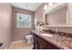 Charming bathroom with granite countertops, a decorative mirror, and natural light from the window at 503 Bonnie Dr, Woodstock, GA 30188