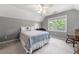 Inviting bedroom with two-toned walls, plush carpet, a bright window, and a ceiling fan at 503 Bonnie Dr, Woodstock, GA 30188