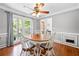 Elegant dining room with hardwood floors, a ceiling fan, and views of the lush backyard at 503 Bonnie Dr, Woodstock, GA 30188