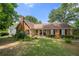 Beautiful brick home with manicured lawn, complemented by green trees and a cozy front porch at 503 Bonnie Dr, Woodstock, GA 30188