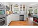 Updated kitchen featuring white cabinets, stainless appliances, decorative backsplash, and hardwood floors at 503 Bonnie Dr, Woodstock, GA 30188