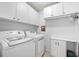 Bright laundry room features a washer, dryer, and ample storage cabinets for convenience at 503 Bonnie Dr, Woodstock, GA 30188