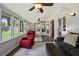 Relaxing sunroom with a ceiling fan, windows, hardwood floors, and comfortable seating at 503 Bonnie Dr, Woodstock, GA 30188