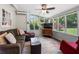 Bright sunroom with lots of windows, ceiling fan, and comfortable seating with hardwood floors at 503 Bonnie Dr, Woodstock, GA 30188