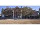 View of the brick community clubhouse surrounded by mature trees and green space at 1023 Bentley Estates Dr, Dacula, GA 30019