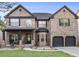 Charming brick two-story home featuring a two-car garage and covered front porch at 1023 Bentley Estates Dr, Dacula, GA 30019