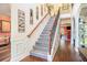 Elegant staircase with hardwood floors, iron railings, and decorative molding, leading to the upper level at 1023 Bentley Estates Dr, Dacula, GA 30019