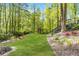 Spacious backyard featuring a playhouse, a creek, and a lush green lawn at 4027 Mount Vernon Dr, Woodstock, GA 30189