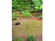Backyard view showcasing a rock-lined creek with natural landscaping, along with a fire pit at 4027 Mount Vernon Dr, Woodstock, GA 30189