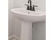 Close up of bathroom pedestal sink with modern black faucet at 4541 Moray Dr, Mableton, GA 30126