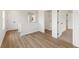 Hallway with luxury vinyl plank flooring leading to laundry room, carpeted bedroom, and closet space at 4541 Moray Dr, Mableton, GA 30126