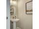 Stylish powder room featuring a pedestal sink, gold fixtures and decorative mirror at 4541 Moray Dr, Mableton, GA 30126