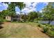 Large sloping backyard that goes to the water featuring a screened in porch and other mature trees at 635 Stone Harbor Sw Pkwy, Marietta, GA 30060