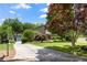 Beautiful home showcasing a lakeside view, a concrete driveway and mature trees in a well-maintained yard at 635 Stone Harbor Sw Pkwy, Marietta, GA 30060