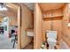 Small barn bathroom with a sink, toilet, shelving and wood siding at 95 Stephens Dr, Covington, GA 30016