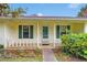Charming front porch with green shutters and well maintained landscaping at entrance at 95 Stephens Dr, Covington, GA 30016