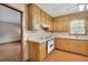 A clean kitchen with wooden cabinets, white appliances, and laminate flooring at 95 Stephens Dr, Covington, GA 30016