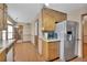 Well-lit kitchen featuring wood cabinets, laminate flooring, and stainless steel refrigerator at 95 Stephens Dr, Covington, GA 30016