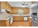 Well-maintained kitchen features wood cabinetry, laminate flooring, and modern stainless steel fridge at 95 Stephens Dr, Covington, GA 30016
