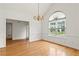 Spacious dining area with hardwood floors, white walls, chandelier and a large arched window at 124 Crown Walk, Mcdonough, GA 30253
