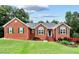 Charming single-story brick home with well-manicured lawn, green shutters, and a welcoming entrance at 124 Crown Walk, Mcdonough, GA 30253