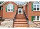 Inviting brick porch with stairs leading to the front door, enhanced by landscaped garden beds at 124 Crown Walk, Mcdonough, GA 30253